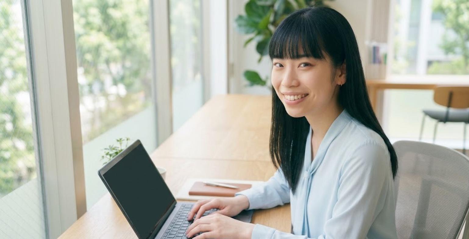 パソコンで作業しながら笑顔で励ますExcel先生